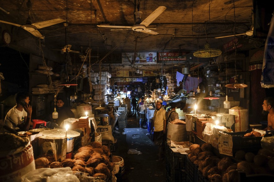 Shopkeepers light candles during power failure in Dhaka, Bangladesh Tuesday Oct. 4, 2022. A failure in Bangladesh&#039;s national power supply grid plunged most of the country into a blackout on Tuesd ...