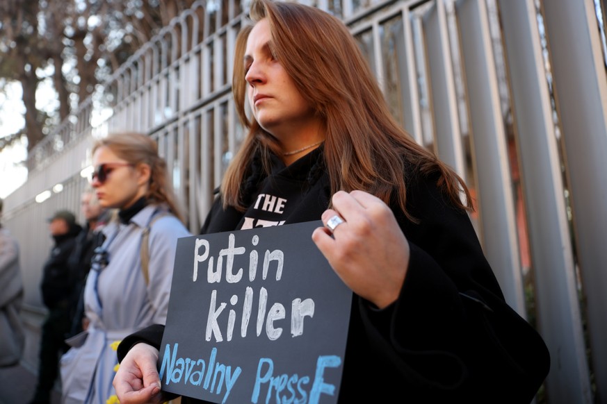 epa11158481 A woman holds a banner reading &#039;Putin killer&#039; during a vigil for the late opposition leader and anti-corruption activist Alexei Navalny following the announcement of his death, i ...