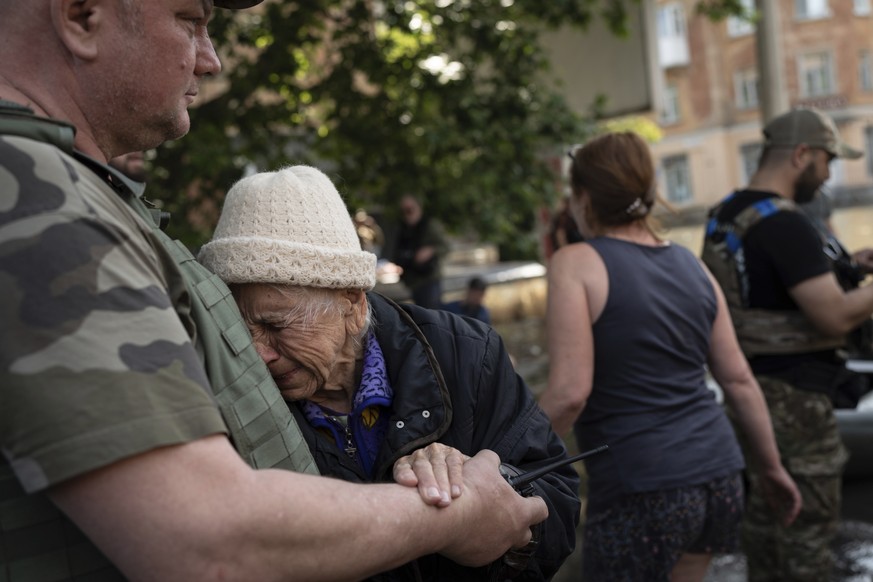 A woman cries as she is evacuated from a flooded neighborhood in Kherson, Ukraine, Wednesday, June 7, 2023 after the Kakhovka dam was blown up. Residents of southern Ukraine braced for a second day of ...