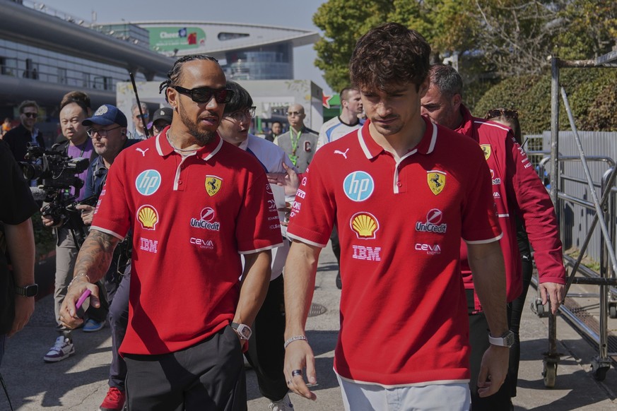 Ferrari driver Lewis Hamilton of Britain, left, chats with his teammate Charles Leclerc of Monaco as they walk out from their team&#039;s hospitality suite ahead of the Chinese Formula One Grand Prix, ...
