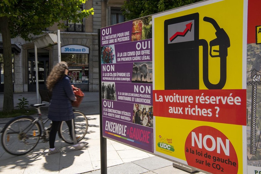 Une personne passe devant des affiches pour les prochaines votations, ce mercredi 26 mai 2021 a Geneve. Les citoyens suisses se prononceront sur cinq objets federaux suivants: &quot;Pour une eau potab ...