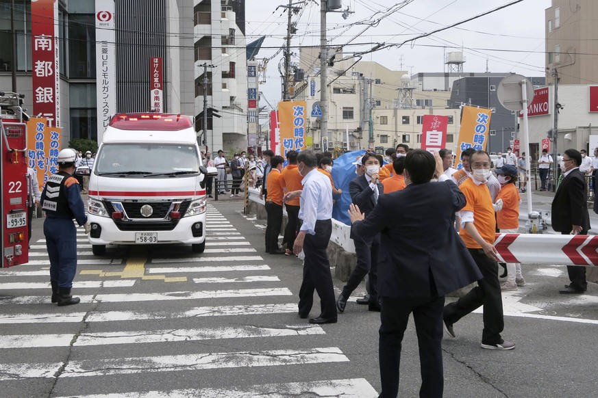 People react after gunshots in Nara, western Japan Friday, July 8, 2022. Japan���s former Prime Minister Shinzo Abe was in heart failure after apparently being shot during a campaign speech Friday in  ...