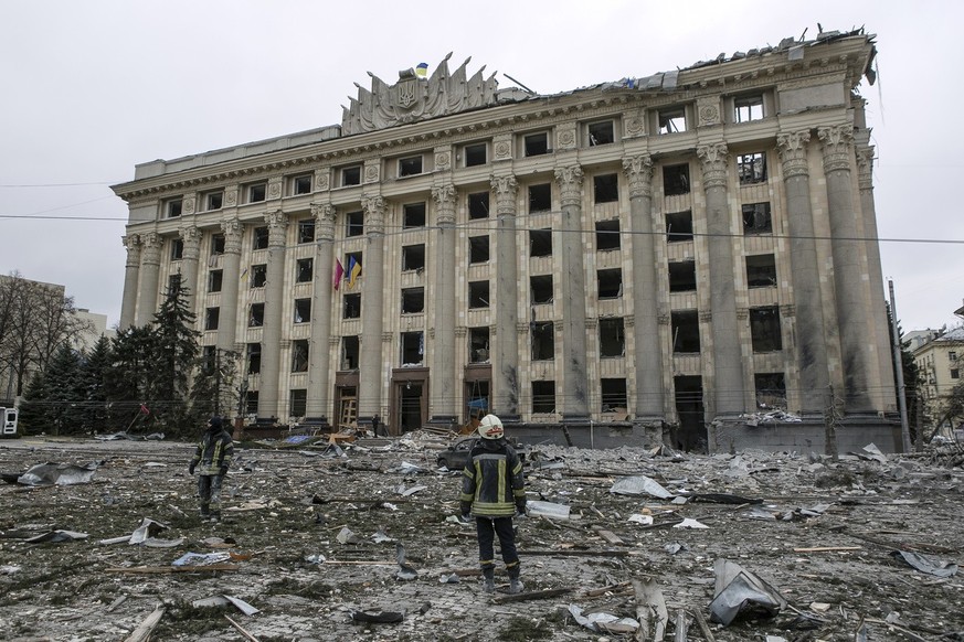 FILE - A member of the Ukrainian Emergency Service looks at the City Hall building in the central square following shelling in Kharkiv, Ukraine, Tuesday, March 1, 2022. (AP Photo/Pavel Dorogoy, File)