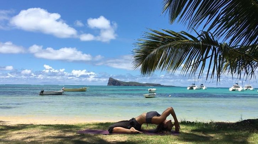 C'est au bord de l'océan indien, dans un décor paradisiaque, que la prof de yoga vaudoise Malika Gavin donne des cours en ligne à ses élèves basés en Europe.