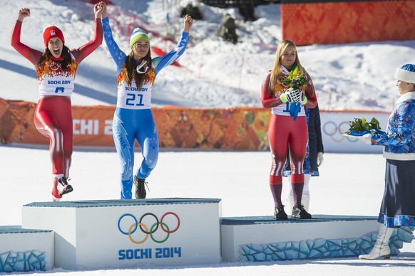 Olympic winner Dominique Gisin of Switzerland, left, and Tina Maze of Slovenia, center, celebrates with Lara Gut of Switzerland, right, during the flowers ceremony after the women&#039;s alpine skiing ...