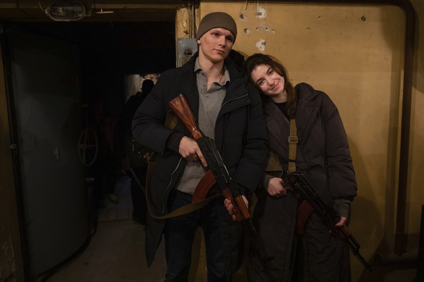 Un jeune couple ukrainien pose pour la caméra avec des armes. 