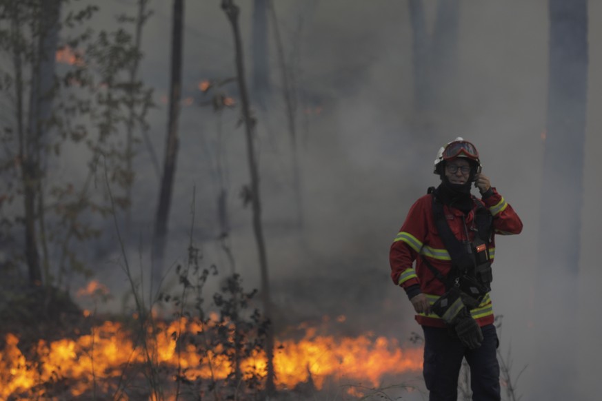epa10064281 Firefighter battles a fire in Cruzinha, Alvaiazere, Portugal, 10 July 2022. The fire that has been burning in forest stands since 07 July in Cumeada, Ourem, remains active and has already  ...