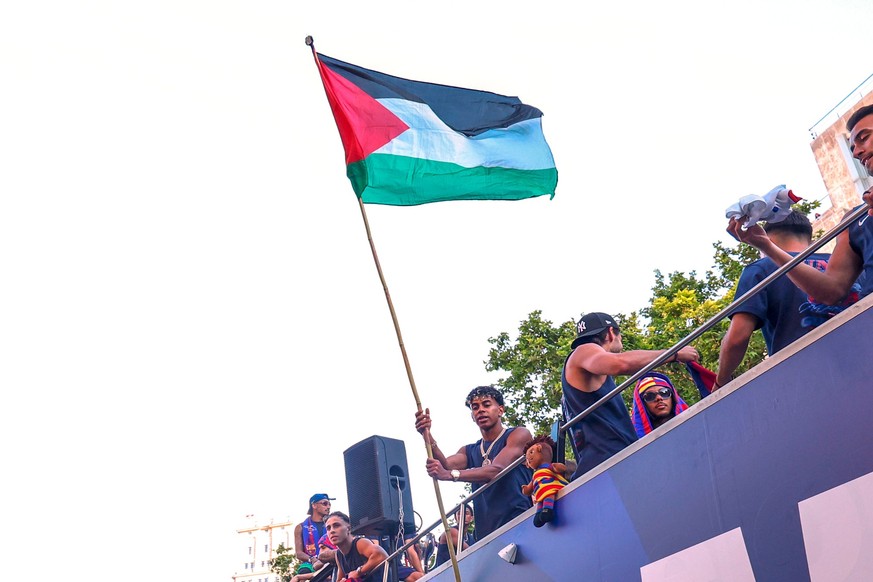 FC Barcelona player Lamine Yamal holds a Palestinian flag as he celebrates with his team atop a bus after winning the Spanish La Liga title in Barcelona, Spain, Monday, May 11, 2026. (AP Photo)