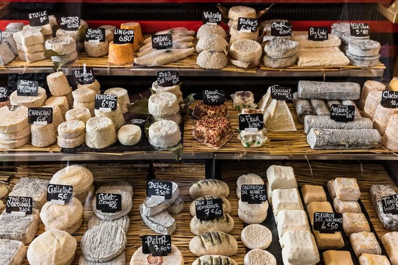 Un présentoir bien fourni avec une sélection de fromages français.