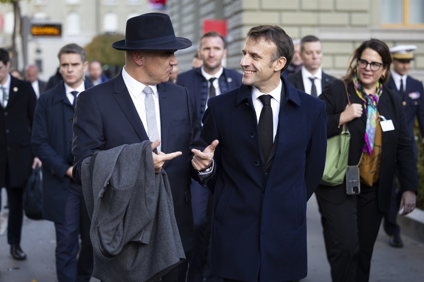 Swiss Federal President Alain Berset, left, and French President Emanuel Macron discuss on their way to the delegation meeting in front of the Federal Palace, the Swiss Parliament building, in Bern, S ...