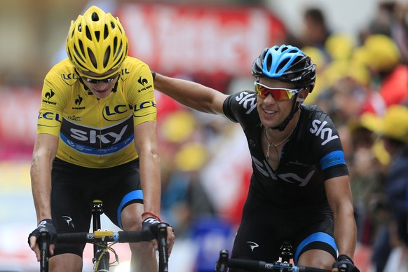 Christopher Froome of Britain, wearing the overall leader&#039;s yellow jersey, is congratulated by teammate Richie Porte of Australia, right, as they cross the finish line of the eighteenth stage of  ...