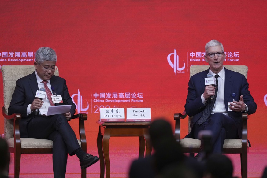 Apple CEO Tim Cook, right, speaks and Dean, School of Economics and Management, Tsinghua University, Bai Chong En, listen during Parallel Session the China Development Forum at the Diaoyutai State Gue ...