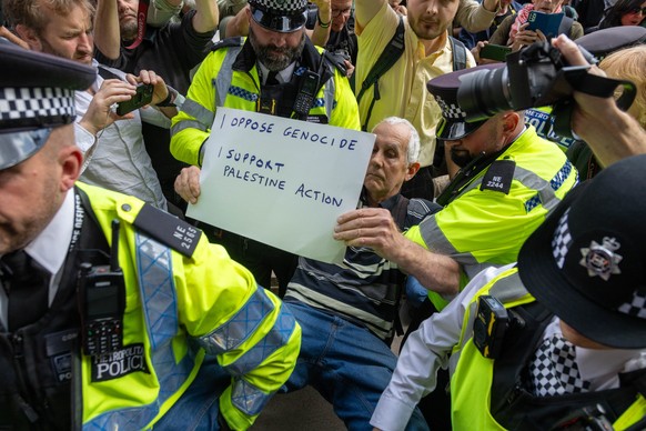epa12357210 Police detain a demonstrator as supporters of the banned Palestine Action group stage a civil disobedience protest in Parliament Square in London, Britain, 06 September 2025. The Metropoli ...