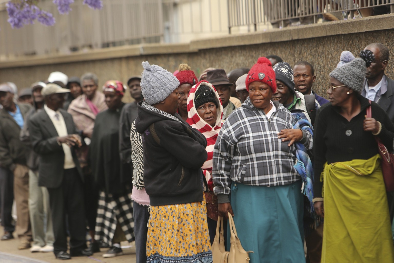 People stand in a queue at a bank in Harare, Thursday Oct. 3, 2019. Zimbabweans are enduring shortages of everything from medicines, fuel, cash and water- bringing a weariness and disgust that has oft ...