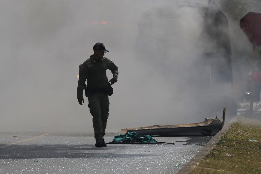 epa12911727 A member of the Colombian Police Anti-Terrorist Explosives Unit walks at the site of a blast outside the Third Army Brigade headquarters in Cali, Colombia, 24 April 2026. A vehicle loaded  ...