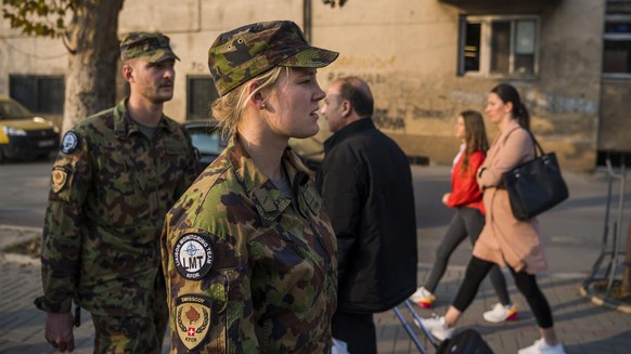 Le Lieutenant Mirko Della Pietra et la soldate Rea Tanner, membres d&#039;une equipe de liaison et de surveillance, LMT, (Liaison and Monitoring Teams) marchent dans les rues de la ville pour discuter ...