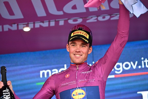 epa12143868 Danish rider Mads Pedersen of Lidl-Trek team, retaining the points classification leader&#039;s cyclamen jersey, celebrates on the podium after the 18th stage of the Giro d&#039;Italia 202 ...