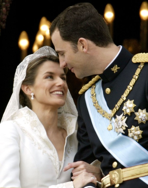 MADRID, SPAIN - MAY 22: Spanish Crown Prince Felipe de Bourbon and his bride Letizia look at each other as the Royal couple appears on the balcony of Royal Palace May 22, 2004 in Madrid. (Photo by Ian ...