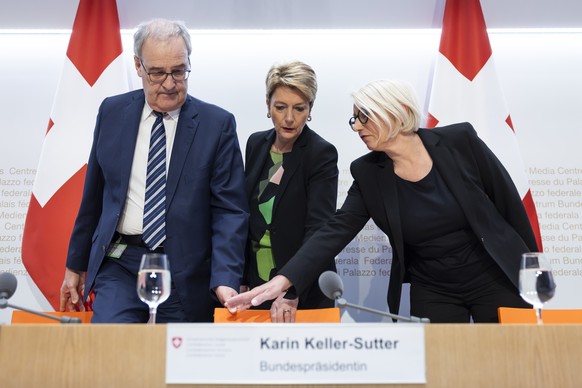 epa12007484 Swiss Federal President Karin Keller-Sutter (C), Federal Councillor Guy Parmelin (L) and Ursula Eggenberger, media spokesperson of the Federal Council, arrive during a press conference on  ...