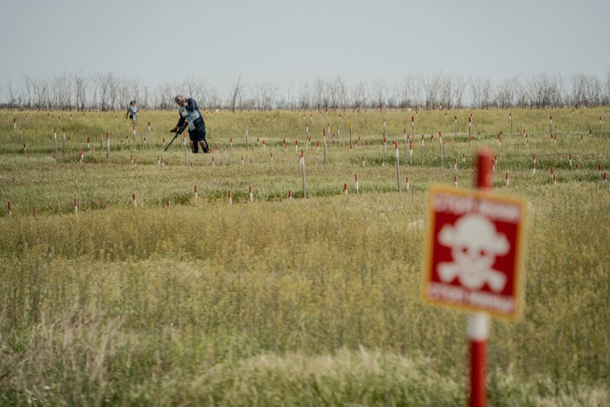 Des employés de HALO Trust travaillent sur un champ de mines près du village de Bezymenne, dans la région de Mykolaiv. Les recherches sont éreintantes, longues et dangereuses.