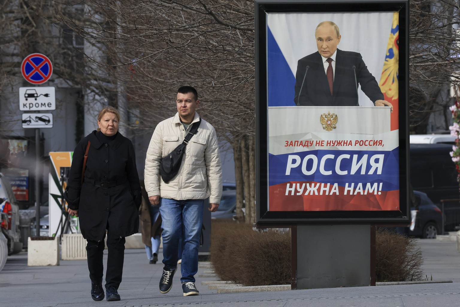 People walk past a billboard with an image of Russian President Vladimir Putin and words reading &quot;The West doesn&#039;t need Russia, we need Russia!&quot; in a street in Sevastopol, Crimea, Wedne ...