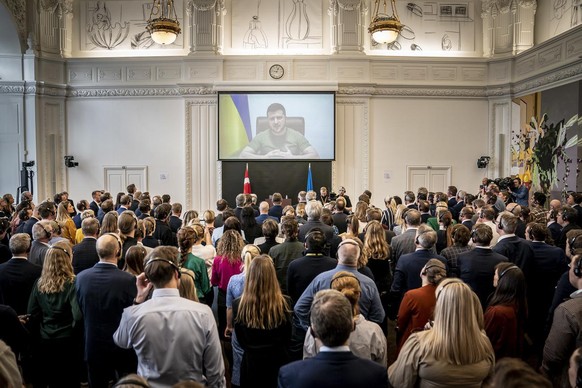 epa09857357 Members of the Danish Parliament attend the Ukrainian President, Volodymyr Zelensky&#039;s speech to the Danish Parliament via a video link, at the Christiansborg Castle in Copenhagen, Den ...