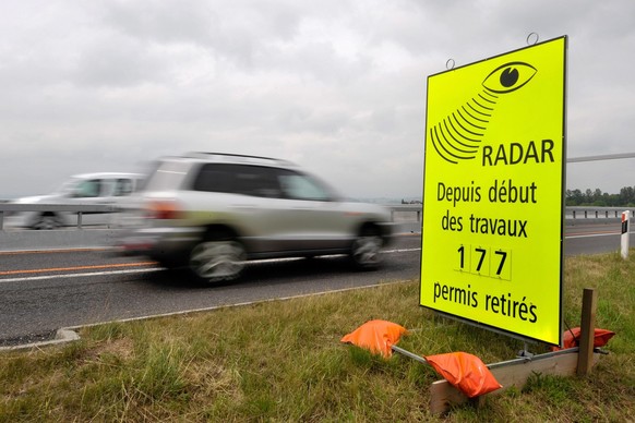 Un vehicule passe devant un panneau de la Police cantonale Vaudoise signalant le nombre de permis de conduire retire pour exces de vitesse dans la zone de travaux sur l'autoroute A1 entre Lausann ...