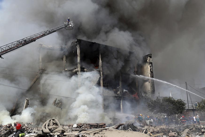 Firefighters extinguish flames as smoke rises from Surmalu market about two kilometers (1.2 miles) south of the center of Yerevan, Armenia, Sunday, Aug. 14, 2022. A strong explosion at a fireworks sto ...