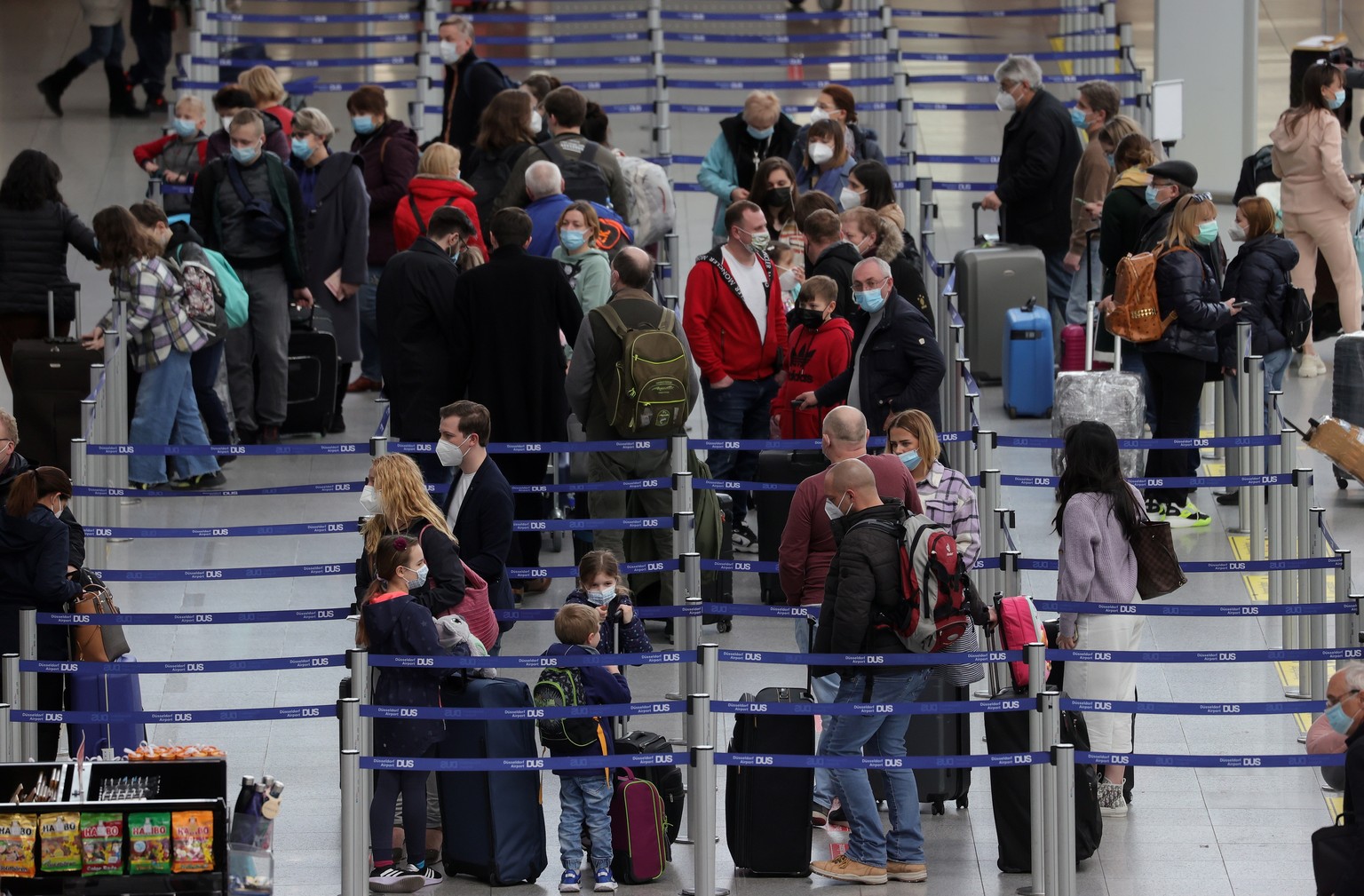 Des passagers attendent dans la file d'enregistrement à l'aéroport international de Düsseldorf à Düsseldorf, en Allemagne, le 26 mars 2021.