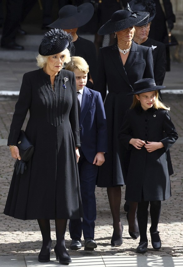 Camilla, the Queen Consort, Prince George, Princess Charlotte, Kate, Princess of Wales, Meghan, Duchess of Sussex, and Sophie, Countess of Wessex, walk outside Westminster Abbey after a service on the ...