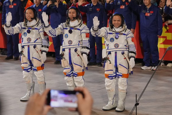Chinese astronaut for the Shenzhou 21 mission, from left, Zhang Hongzhang, Wu Fei and Zhang Lu wave as they attend a see-off ceremony for their manned space mission at the Jiuquan Satellite Launch Cen ...
