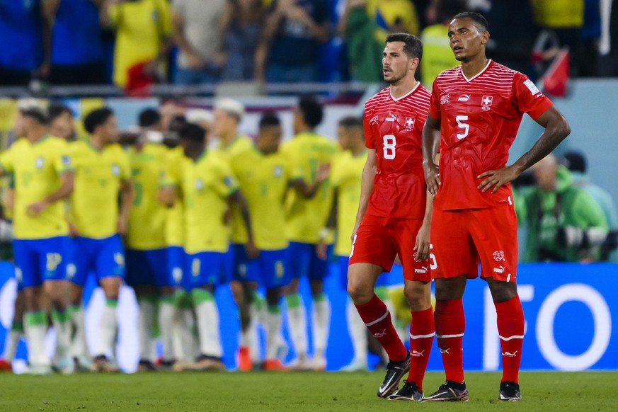 Switzerland's midfielder Remo Freuler and Switzerland's defender Manuel Akanji, react to the celebration of the Brazilian players on the cancelled goal from Brazil's forward Vinicius Junior during the ...