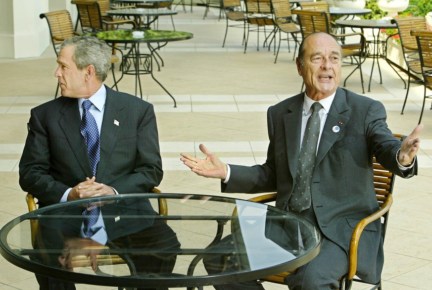 President Bush, left, glances left to find his interpreter as G8 Summit host, French President Jacques Chirac, begins speaking French as they meet near the end of the economic gathering in Evian, Fran ...
