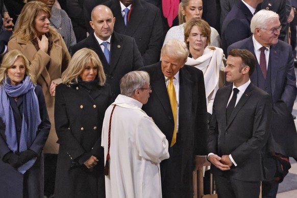 epa11763370 French President Emmanuel Macron (R) and US President-elect Donald Trump (C-R) talk to a member of the clergy at the end of a ceremony marking the official reopening of the Notre Dame de P ...