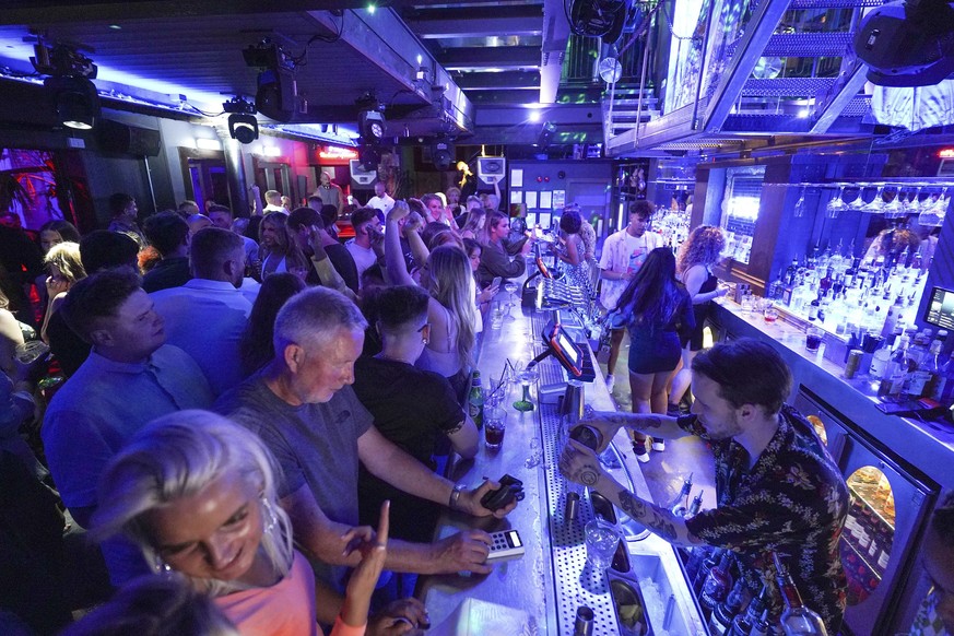 People gather at Bar Fibre in Leeds, after the final legal coronavirus restrictions were lifted in England at midnight, Monday, July 19, 2021. (Ioannis Alexopoulos/PA via AP)