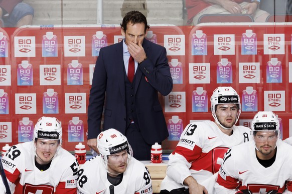 Patrick Fischer, head coach of Switzerland national ice hockey team, gestures behind his players Switzerland&#039;s forward Dario Simion #59, Switzerland&#039;s forward Christoph Bertschy #88, Switzer ...