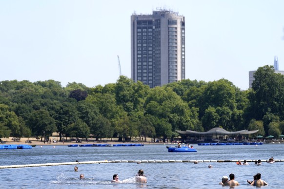 People cool down in the water of The Serpentine Lake in Hyde Park in London, Tuesday, July 19, 2022. Britain shattered its record for highest temperature ever registered amid a heat wave that has seiz ...