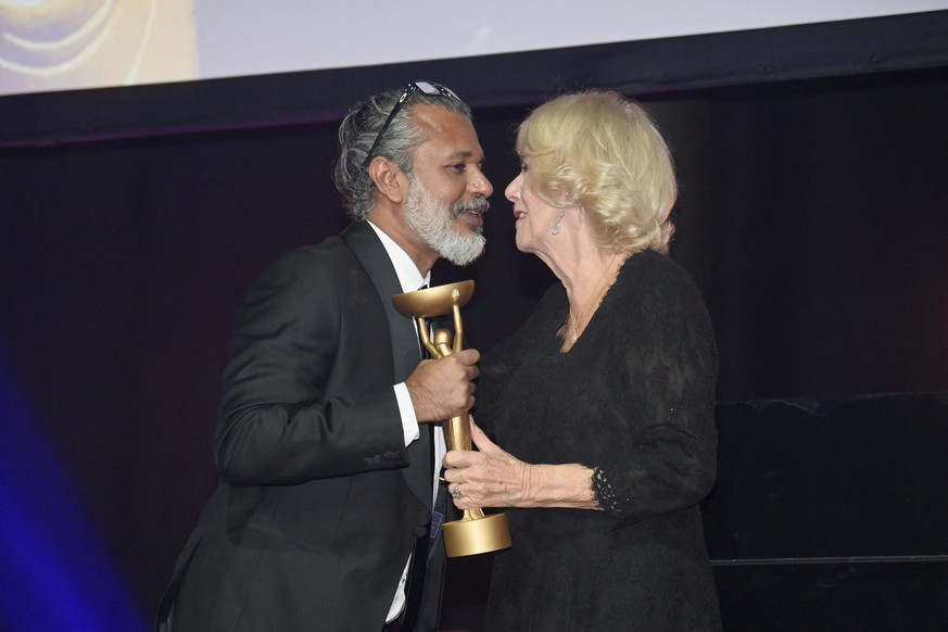 Britain&#039;s Camilla, Queen Consort, presents winner Shehan Karunatilaka with the trophee for &quot;The Seven Moons of Maali Almeida&quot; during the Booker Prize at the Roundhouse in London, Monday ...