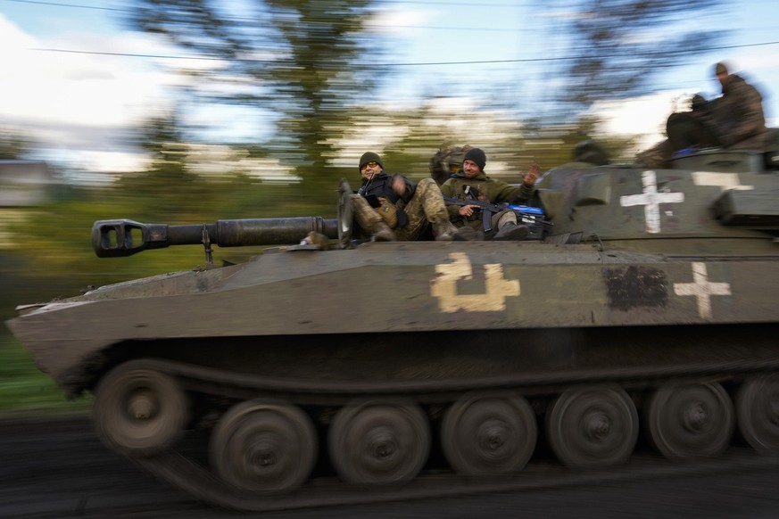 Ukrainian soldiers drive on a tank as they cross the village of Shandrygolovo, near Lyman, Ukraine, Tuesday, Oct. 4, 2022. (AP Photo/Francisco Seco)
