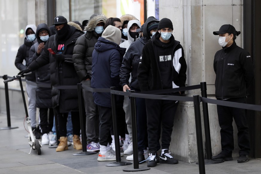 People queue to enter a Nike Town shop on Oxford Street in London, early Monday morning, April 12, 2021. Millions of people in England will get their first chance in months for haircuts, casual shoppi ...