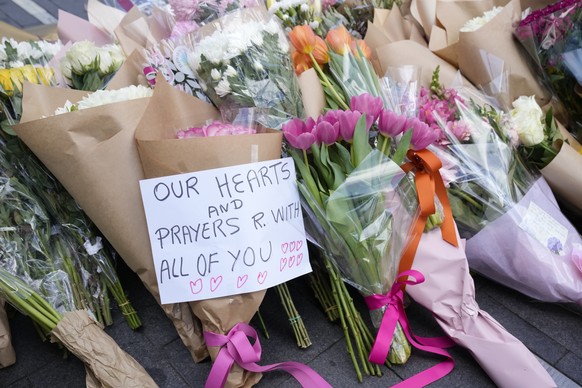 A note is left with flower tributes near a crime scene at Bondi Junction in Sydney, Sunday, April 14, 2024, after several people were stabbed to death at a shopping center Saturday. Police have identi ...