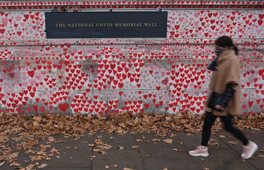 epa09600854 A woman walks past The National Covid Memorial Wall, a tribute to those who died with Covid-19, in London, Britain, 24 November 2021. EPA/NEIL HALL