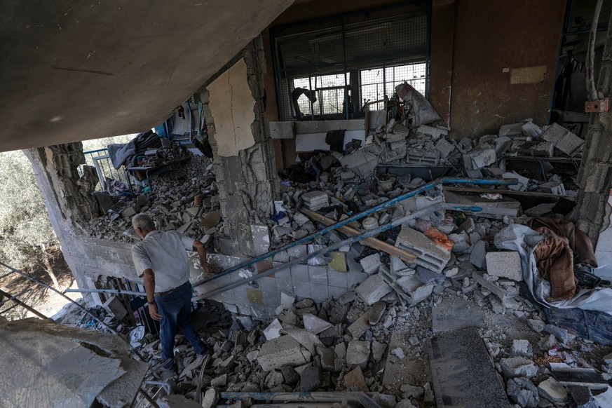 epa11478473 A Palestinian inspects a damaged UNRWA school following an Israeli air strike in Al Nuseirat refugee camp, central Gaza Strip, 14 July 2024. At least 12 people were killed following an Isr ...
