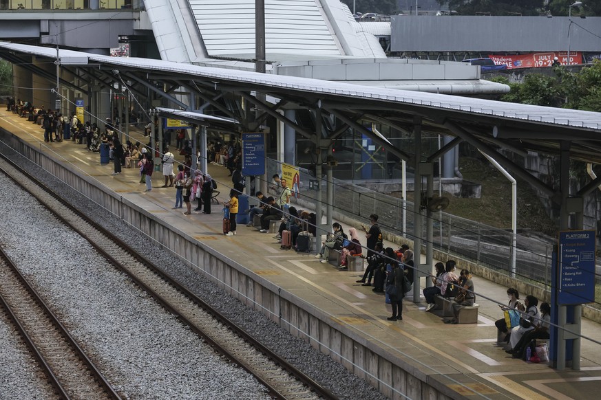 epa11487405 People wait for the train at Sungai Buloh station, outside Kuala Lumpur, Malaysia, 19 July 2024. Malaysia&#039;s railway operator KTMB confirmed that its KITS ticketing system, as well as  ...