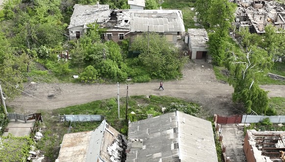 This photo taken from a drone video provided by Ukraine Patrol Police, shows a man walking through devastation in Chasiv Yar, an eastern Ukrainian city Russia is assaulting, Ukraine, Monday, April 29, ...