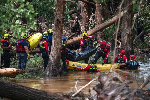 Firefighters from Ciudad Acu�a, Mexico, load a body into a raft as they prepare for a water recovery along the Guadalupe River days after a flash flood swept through the area, Monday, July 7, 2025, in ...