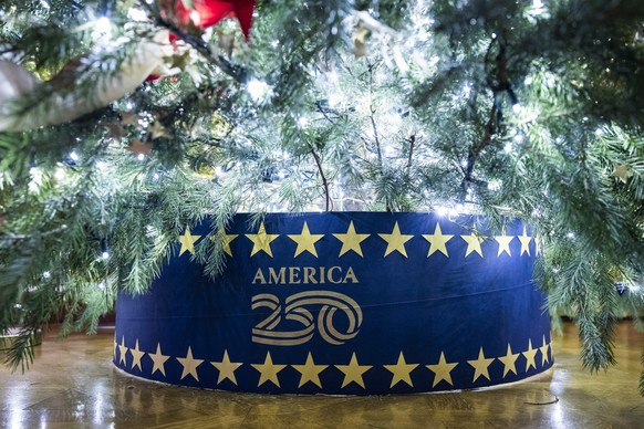 epa12562166 A decoration highlighting the upcoming 250th anniversary of the signing of the Declaration of Independence on the base of a Christmas tree on display in the East Room of the White House du ...