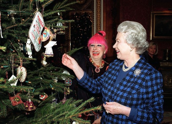 LONDON - DECEMBER 15: Queen Elizabeth II and fashion designer Zandra Rhodes admire Christmas decorations on the Christmas tree in the Picture Gallery at Buckingham Palace after meeting representatives ...
