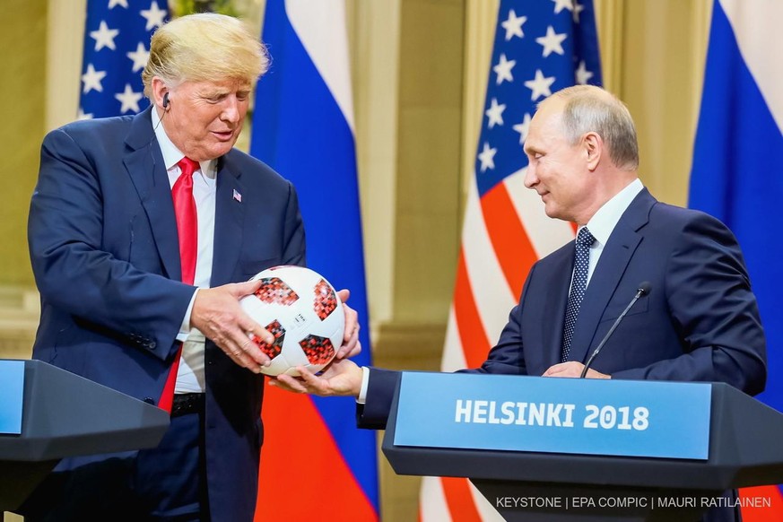 L'ancien président américain Donald J. Trump (à gauche) reçoit un ballon de football de la Coupe du monde de la Fifa 2018 des mains du président russe Vladimir Poutine à Helsinki, en Finlande, le 16 juillet 2018. 