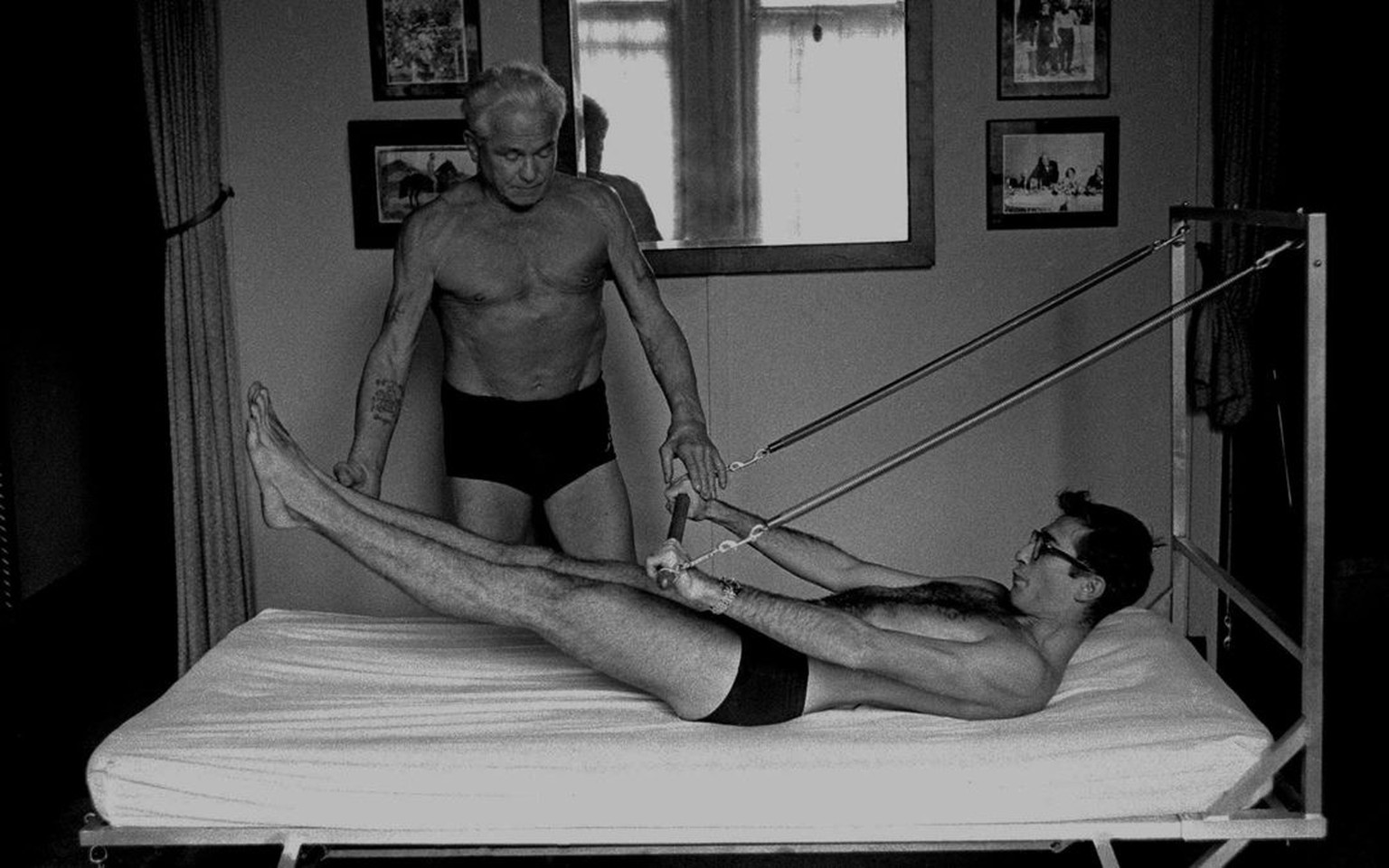 NEW YORK - OCTOBER 1961: Joe Pilates, Inventor, physical fitness guru and founder of the Pilates exercise method demonstrates a technique on his &#039;Bednasium&#039; in his 8th Avenue studio on Octob ...